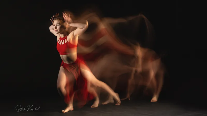Dancer in a red costume in a long-exposure photo showing blurred trails of movement