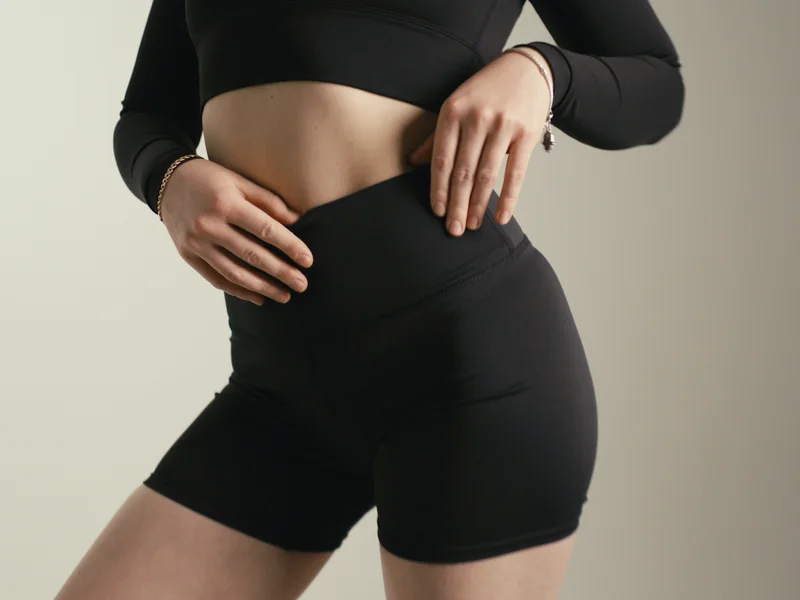 Revival still: close-up of REVIVE activewear shorts and long-sleeve crop top